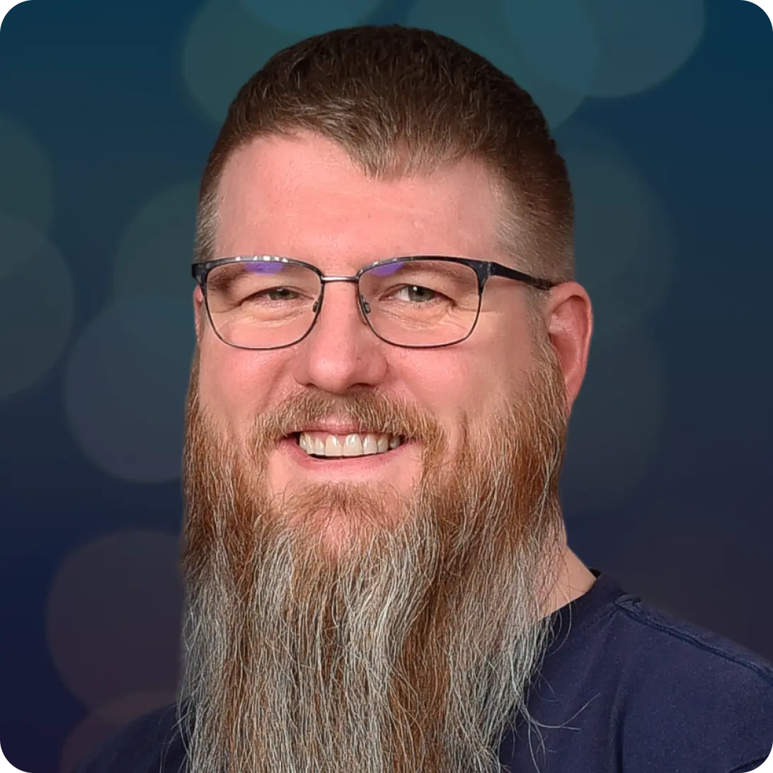 Smiling man with glasses and a long beard.