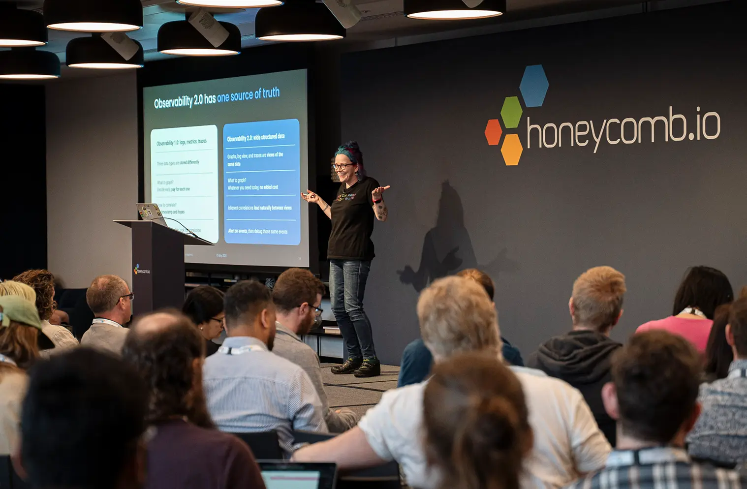 Charity Majors on stage with Honeycomb.io logo