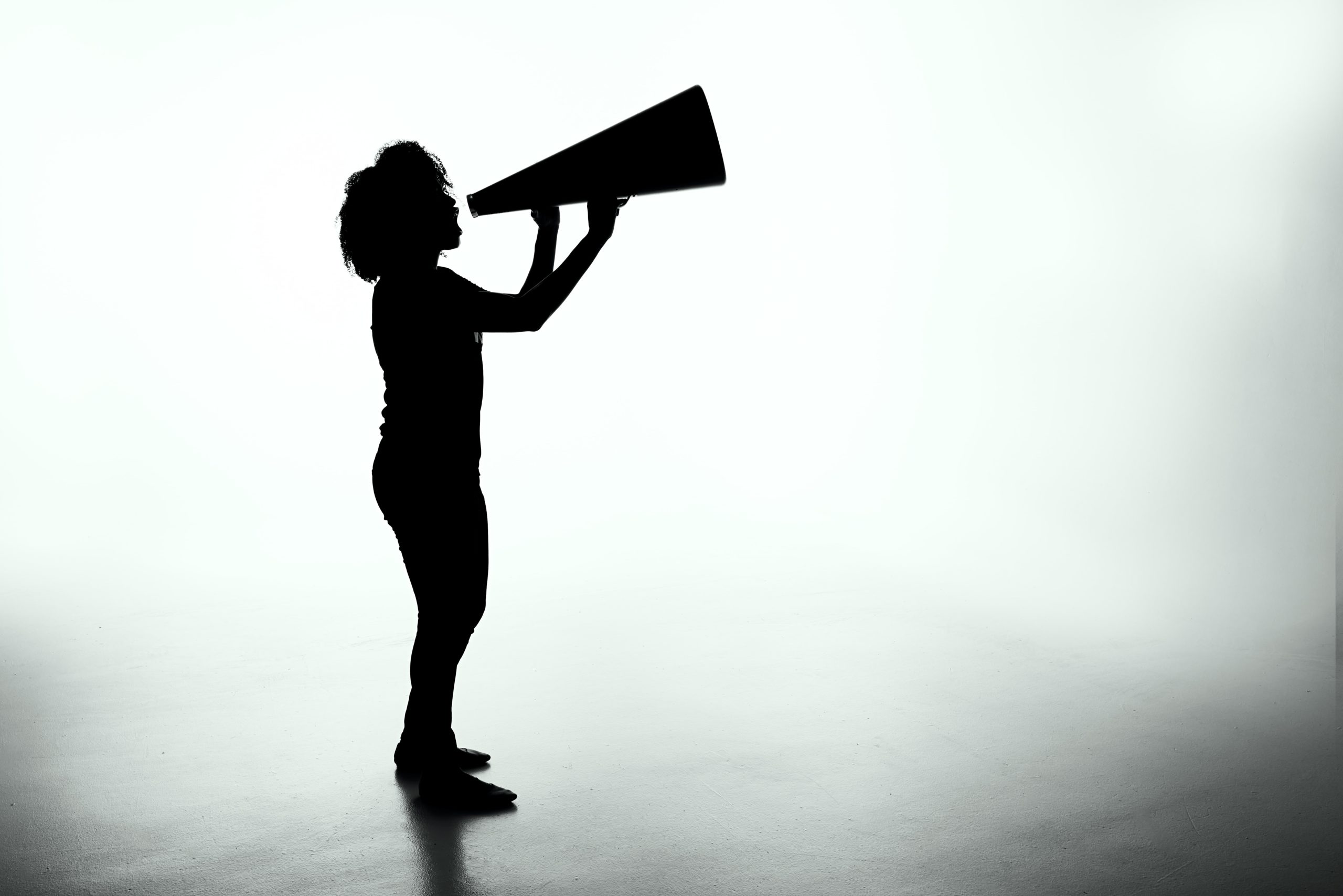 silhouette of person talking into megaphone